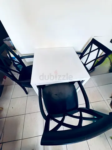 Compact white square dining table with 3 black chairs - good condition