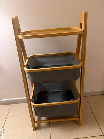 Light wood ladder-style shelving unit with fabric baskets
