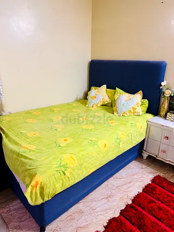 Single blue upholstered bed with headboard — good condition