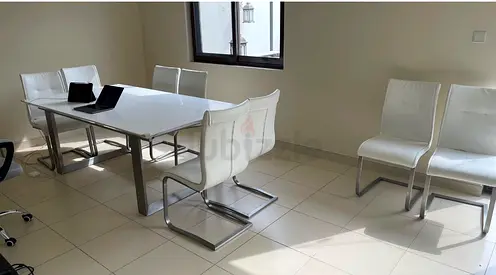 White modern dining table with 10 matching cantilever chairs