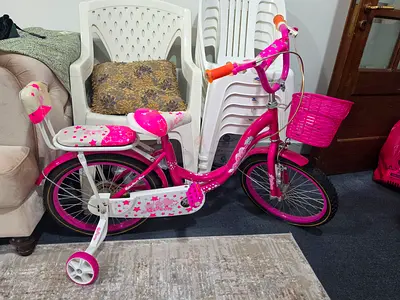Pink girls kids bicycle with training wheels and basket - good condition