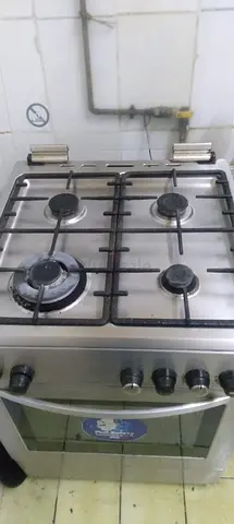 Used stainless steel gas stove with oven - functional, 4 burners, 200 AED