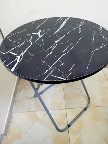 Round folding side table with black marble-effect top
