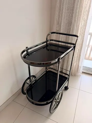 Vintage-style black glass trolley cart on wheels
