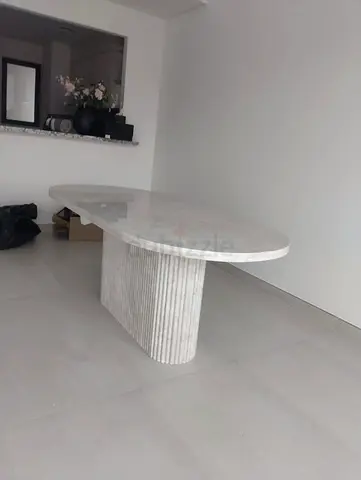 Marble dining table with oval top and fluted pedestal base