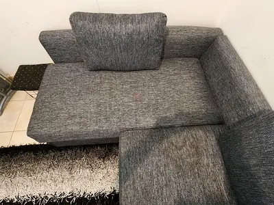 Grey L-shaped sofa bed, Fabric Good Condition. Include 3 cushions and carpet