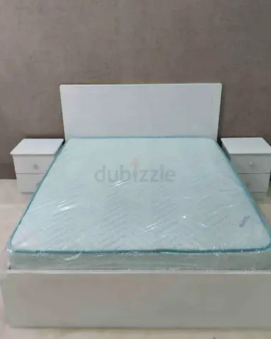 White double bed frame with mattress and two bedside tables