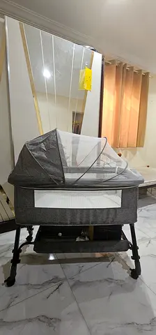 Grey bedside bassinet with canopy and mosquito net - gently used