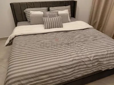 King size upholstered bed frame with mattress. The bed has two USB chargers, storage space.