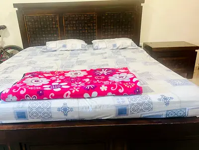 Solid dark wood king-size bed with headboard and storage