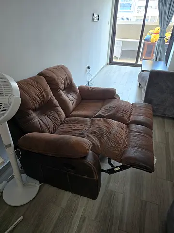Two-seater brown reclining sofa in good used condition