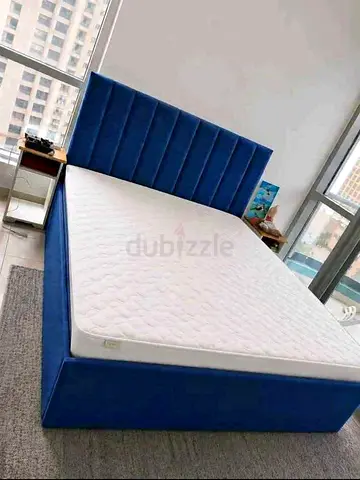 Blue upholstered double bed frame with padded headboard