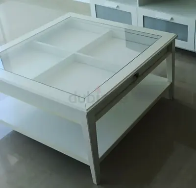 White square glass-top coffee table with lower shelf and storage compartments