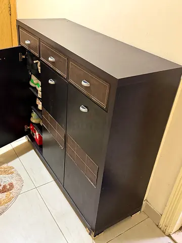 Dark wood storage cabinet with multiple drawers and compartments