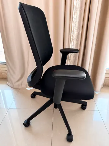 Black ergonomic office chair with armrests and wheels