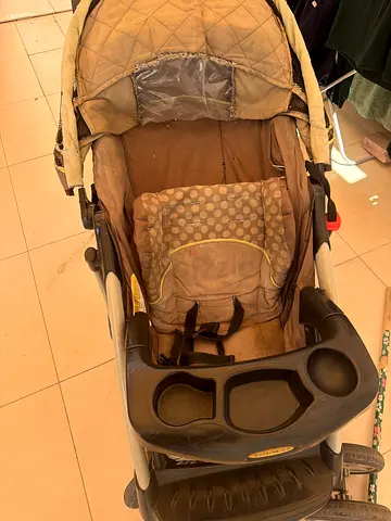 Well-used standard baby stroller with tray and canopy