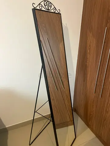 Full-length freestanding mirror with black metal frame and stand