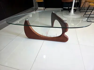 Mid-century style glass top coffee table with wooden sculpted base.