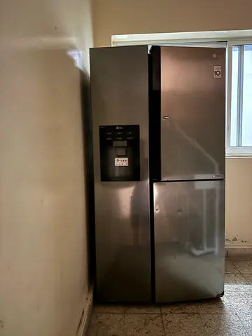 Large stainless steel side-by-side refrigerator with water dispenser - used