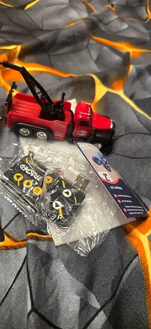 Small red toy tow truck with accessory parts, good condition