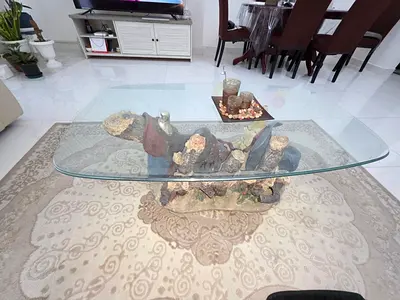 Unique glass-top coffee table with carved wooden base