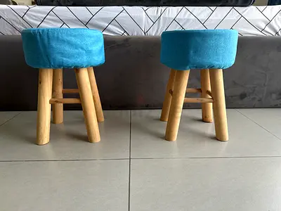 Pair of small wooden round stools with blue upholstery
