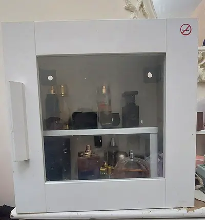 Small white wall-mounted medicine/cosmetic cabinet with glass door