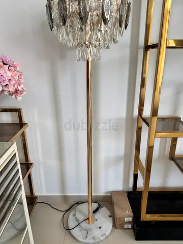 Tall gold floor lamp with crystal accents and marble base.