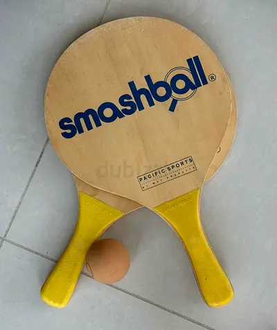 Pair of wooden Smashball beach paddleball rackets with ball