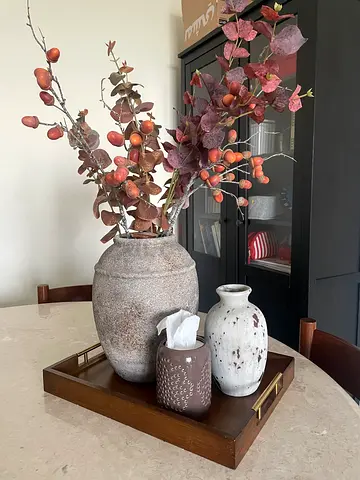 Set of decorative ceramic vases with wooden tray and faux foliage