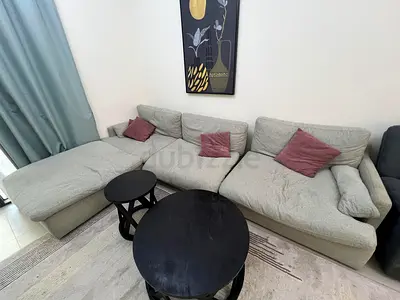 Light grey L-shaped fabric sofa with chaise and cushions