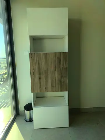 Tall white storage cabinet with wood-finish door - slim vertical unit