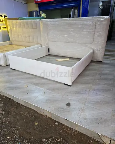 White upholstered queen bed frame with padded headboard
