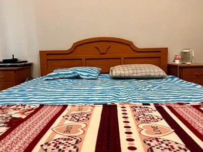 Wooden double bed with headboard and matching bedside tables, wardrobe and dressing table