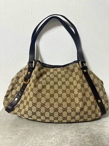 Gucci STYLE Abbey shoulder bag crafted from beige GG canvas with dark brown leather trim
