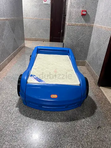 Blue car-shaped toddler bed with mattress