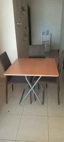Compact folding dining table with 3 chairs - light wood and a small glass rack