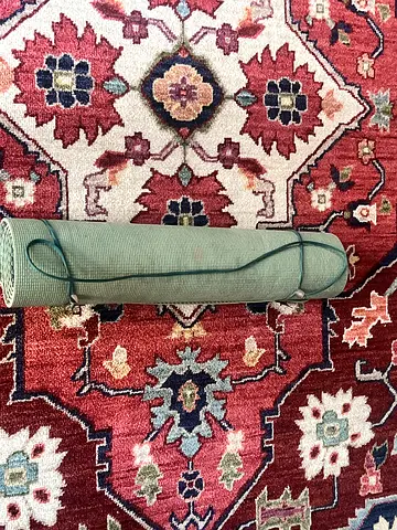 Used green yoga mat with carrying strap — good condition