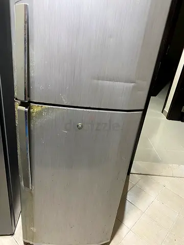 Used double-door refrigerator with minor dents and wear
