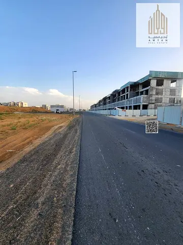 Commercial land for sale in Al Helio 2, Ajman, on a main street. Ground floor and mezzanine permit.