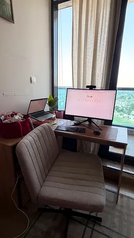Compact home office desk with swivel chair and monitor setup