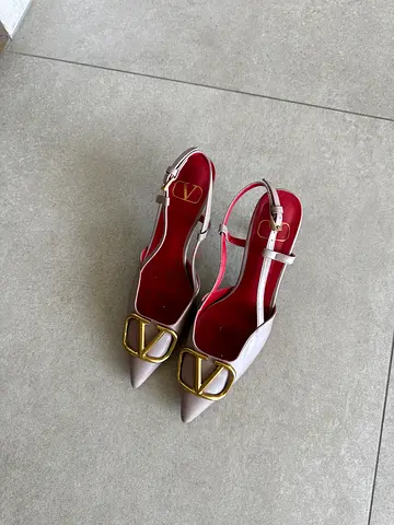 Light pink pointed slingback heels with gold buckle