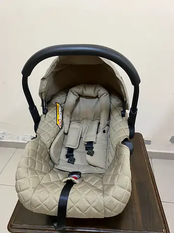 Infant car seat with quilted beige fabric and sun canopy
