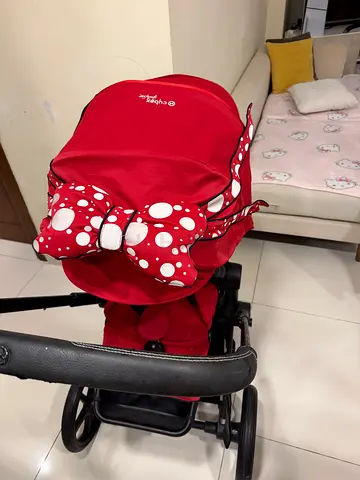 Red baby stroller/pram in good condition with bow canopy