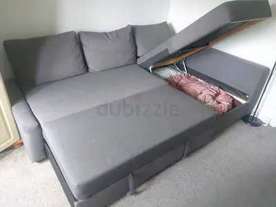 Grey L-shaped sofa bed with storage — good condition