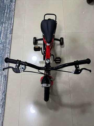 Red kids tricycle with training wheels - good condition