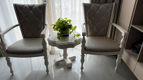 Pair of grey upholstered accent chairs with small white side table
