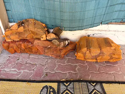 Bagged firewood logs for barbecue or fireplace - used, dry