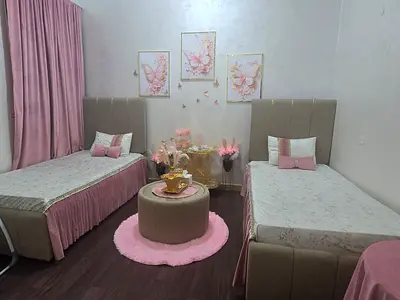 Pair of single beds with headboards and matching bedside setup - pink accents