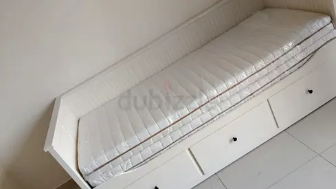 White wooden daybed with storage drawers and mattress